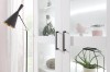Moderne weiße Glasvitrine mit markanten schwarzen Griffen und dekorativem Inhalt im Wohnzimmer.