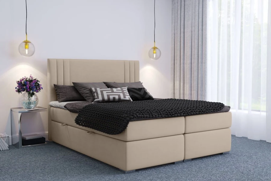 Beiges Boxspringbett mit gepolstertem Kopfteil und dunkler Bettwäsche in modernem Schlafzimmer.