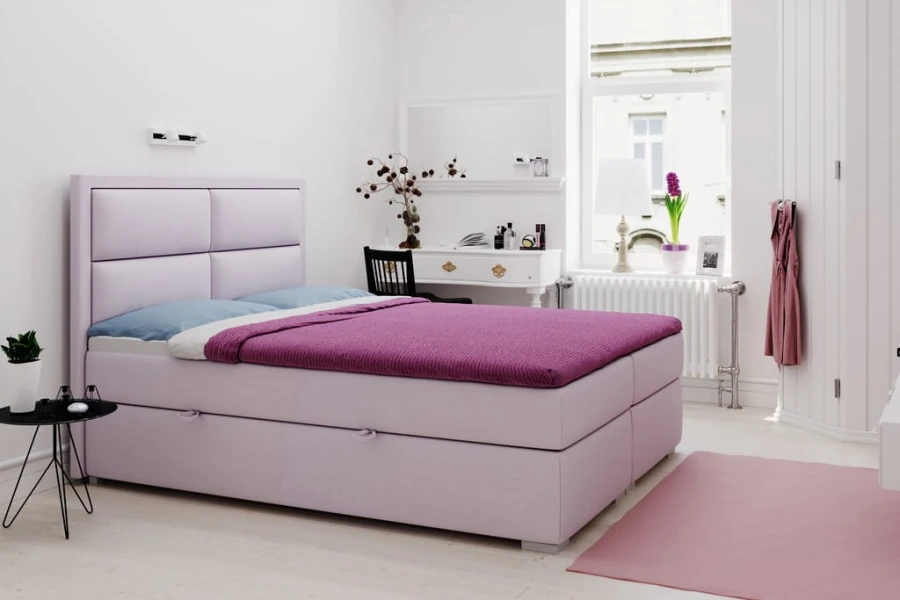 Gemütliches Schlafzimmer mit fliederfarbenem Boxspringbett und pinkem Läufer.