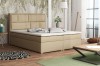 Modernes beiges Boxspringbett in hellem Schlafzimmer mit großen Fenstern
