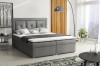 Graues Boxspringbett mit gepolstertem Kopfteil in modernem Schlafzimmer.