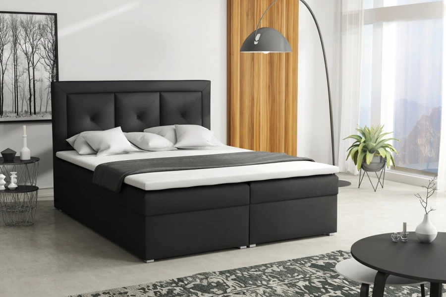 Modernes schwarzes Boxspringbett mit gepolstertem Kopfteil im Schlafzimmer.