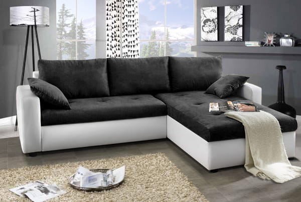 Modernes Ecksofa in Schwarz und Weiß inklusive Kissen für das Wohnzimmer.