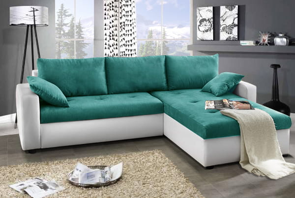 Farbenfrohes Ecksofa in Türkis und Weiß als Blickfang im Wohnzimmer.