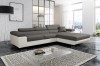 Ecksofa Grau-Weiß in modernem Wohnzimmer-Ambiente mit Design-Teppich.