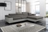 Stilvolle graue Eckcouch mit weißem Korpus und Metallfüßen auf Design-Teppich.