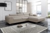 Beiges Ecksofa in minimalistischem Wohnzimmer mit stilvoller Dekoration und Teppich.