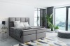 Elegantes graues Boxspringbett in modernem Zimmer mit Loft-Feeling.