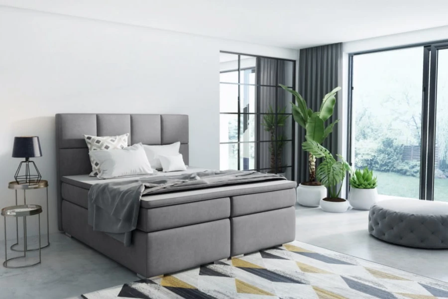 Elegantes graues Boxspringbett in modernem Zimmer mit Loft-Feeling.