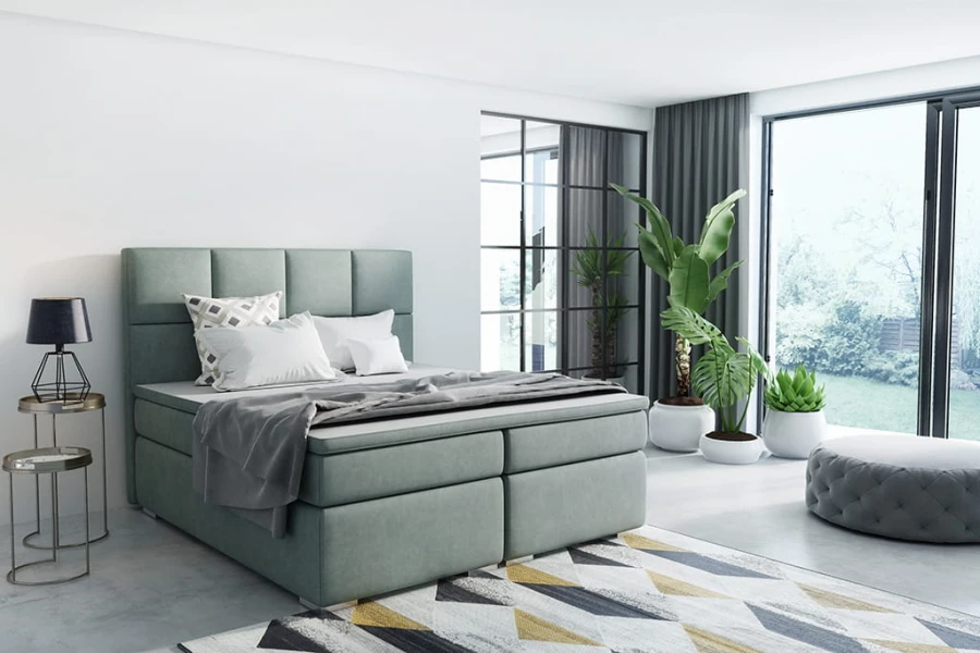 Modernes salbeigrünes Boxspringbett in hellem Schlafzimmer mit großen Fenstern.