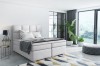 Elegantes hellgraues Boxspringbett für modernes Schlafzimmer-Design.
