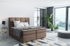 Braunes Boxspringbett in Mokka-Optik in gemütlich eingerichtetem Raum.