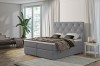 Graues Boxspringbett mit eleganter Knopfheftung am Kopfteil