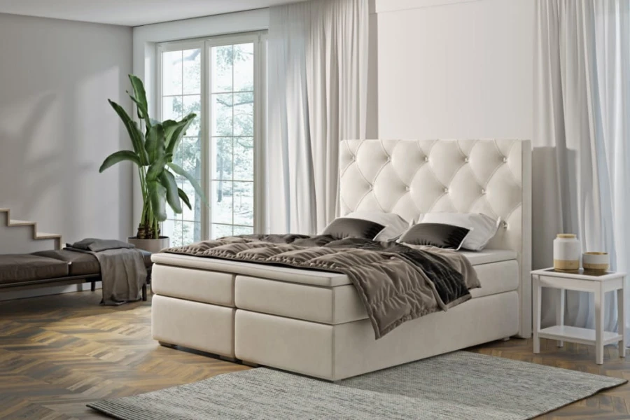 Cremefarbenes Boxspringbett mit dekorativem Kopfteil und gemütlicher Optik