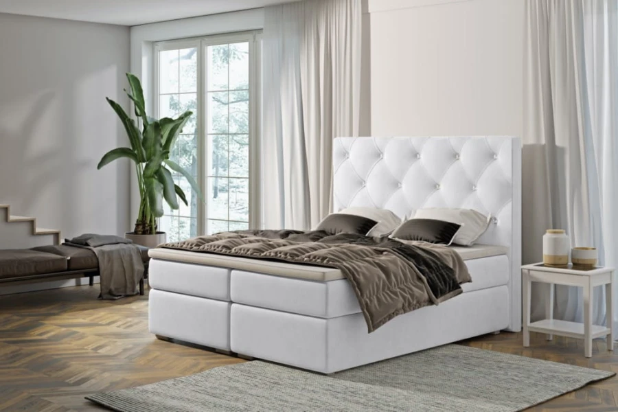 Weißes Boxspringbett mit gestepptem Kopfteil im modern eingerichteten Schlafzimmer mit Parkett.