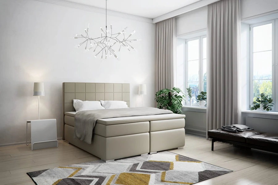 Modernes Boxspringbett in Beige in einem hellen, stilvollen Schlafzimmer mit Teppich und Pflanzen.
