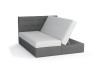 Graues Boxspringbett mit gestepptem Kopfteil und einseitig geöffnetem Bettkasten.