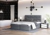 Graues gepolstertes Bett in luxuriösem Schlafzimmer mit Badewanne und geometrischer Wandgestaltung.