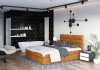 Modernes senfgelbes Boxspringbett in stilvollem Schlafzimmer mit freistehender Badewanne.