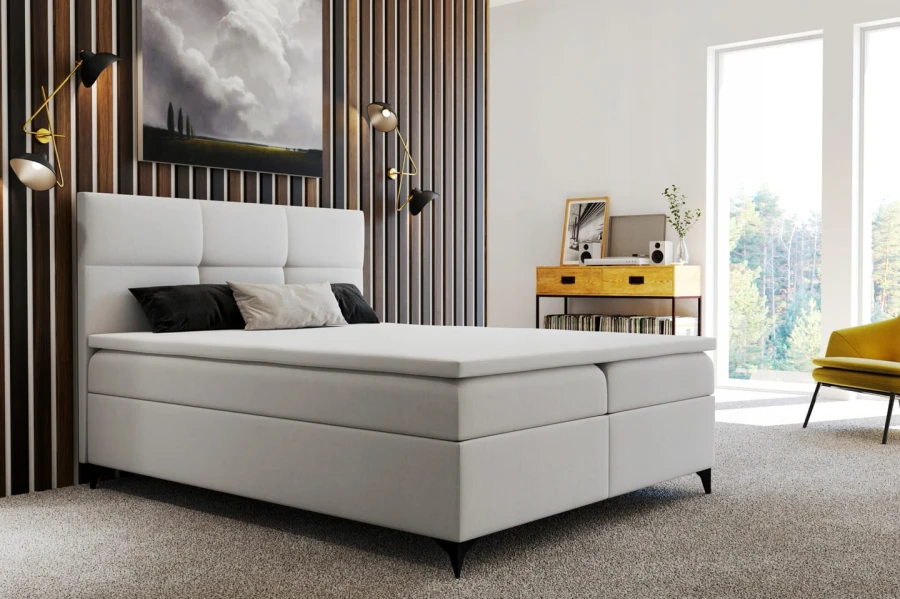 Hellgraues Boxspringbett in einem modernen Schlafzimmer mit Holzpaneelen an der Wand.