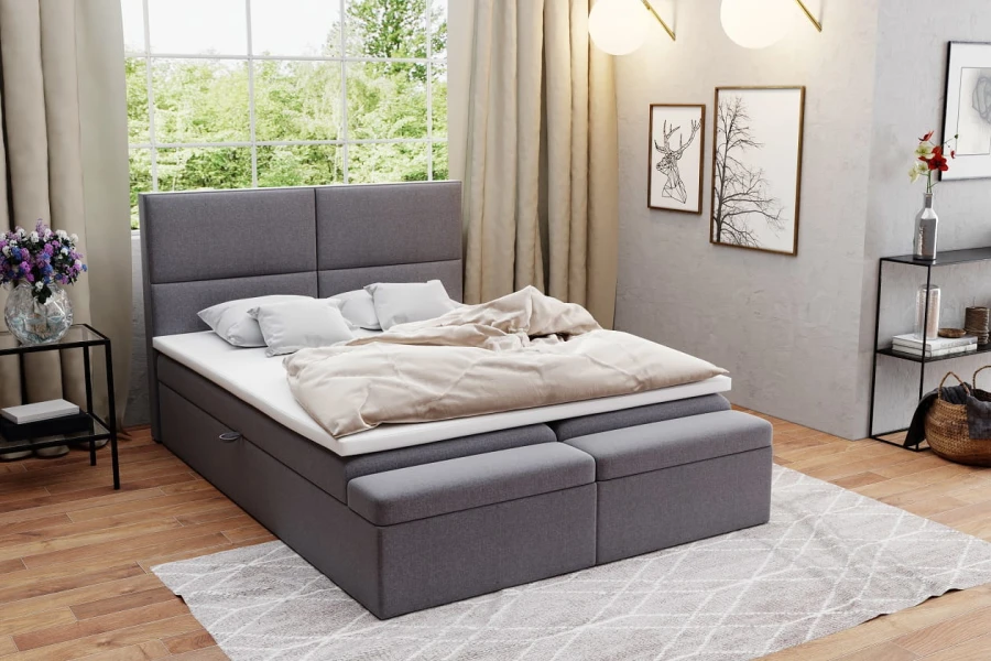 Gemütliches graues Boxspringbett mit gepolstertem Kopfteil und passender Bettbank im Schlafzimmer.