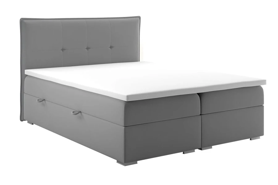 Klassisches Boxspringbett in Grau mit weißem Topper und Steppung am Kopfteil.