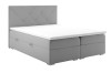 Graues Boxspringbett mit Rautensteppung am Kopfteil und weißem Topper.