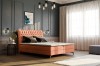 Korallefarbenes Boxspringbett im modern eingerichteten Schlafzimmer