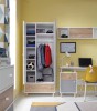 Kinderzimmer-Einrichtung mit weißem Schreibtisch, gelbem Stuhl und offenem Kleiderschrank in Weiß-Grau.