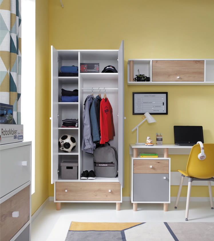 Kinderzimmer-Einrichtung mit weißem Schreibtisch, gelbem Stuhl und offenem Kleiderschrank in Weiß-Grau.