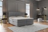 Graues Boxspringbett mit dekorativem Kopfteil in einem modern eingerichteten Schlafzimmer.