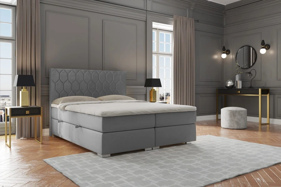 Graues Boxspringbett mit dekorativem Kopfteil in einem modern eingerichteten Schlafzimmer.
