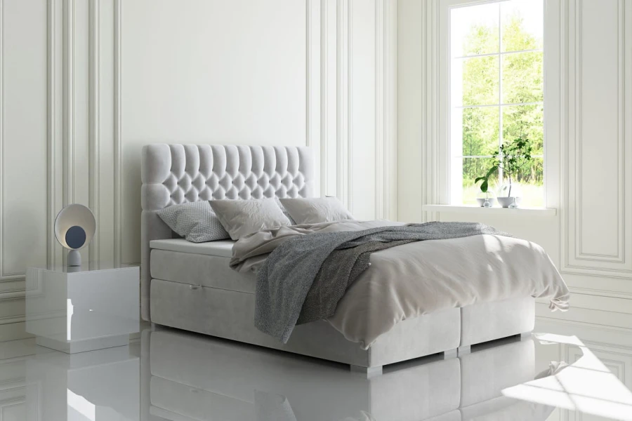 Modernes hellgraues Boxspringbett mit gestepptem Kopfteil in weißem Schlafzimmer
