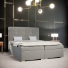Luxuriöses graues Boxspringbett mit hohem Kopfteil in modernem, dunklem Schlafzimmer.