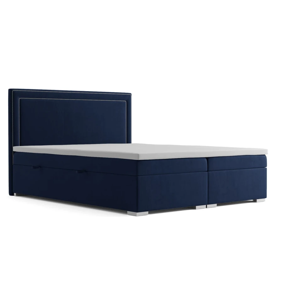 Dunkelblaues Boxspringbett mit hohem Kopfteil und weißer Matratze auf weißem Hintergrund.