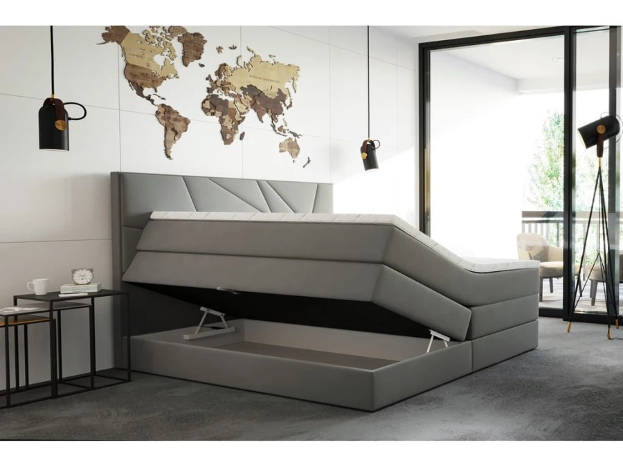 Graues Boxspringbett mit geöffnetem Bettkasten und Stauraum im modernen Schlafzimmer.