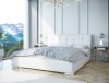 Modernes Schlafzimmer-Design mit stilvollem weißem Polsterbett und Bergblick.