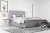 Hellgraues Boxspringbett mit weicher Polsterung für ein modernes Schlafzimmer-Ambiente.