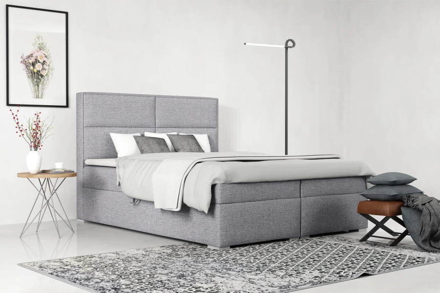 Hellgraues Boxspringbett mit weicher Polsterung für ein modernes Schlafzimmer-Ambiente.