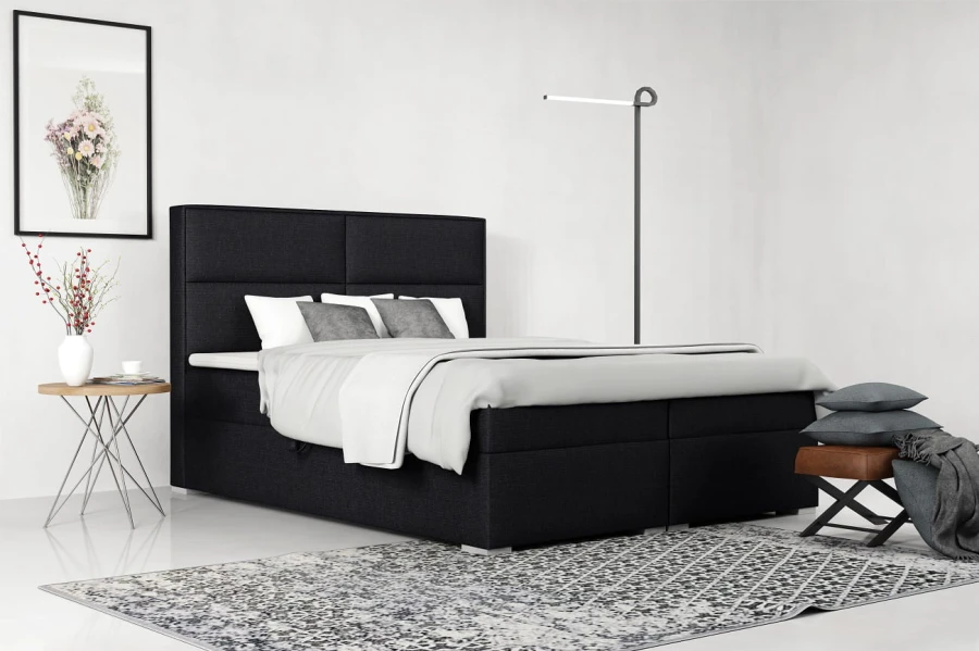 Modernes Boxspringbett in Schwarz mit gepolstertem Kopfteil im hellen Schlafzimmer.