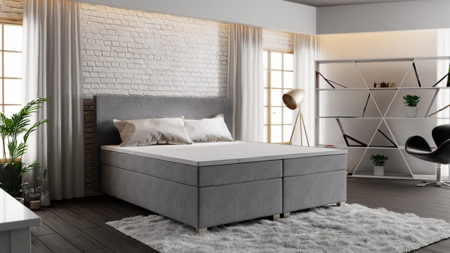 Graues Boxspringbett in einem modernen Schlafzimmer mit Backsteinwand und Loft-Stil.
