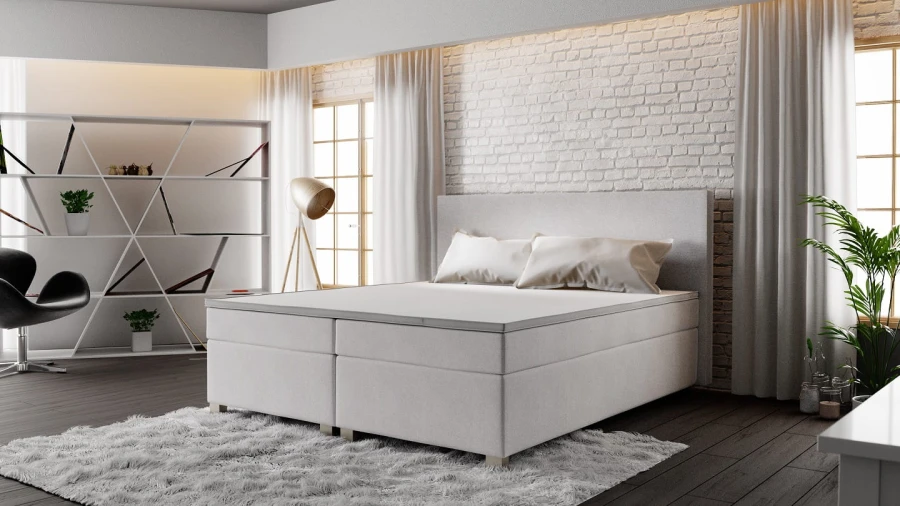 Hellgraues Boxspringbett in einem stilvoll eingerichteten Schlafzimmer.