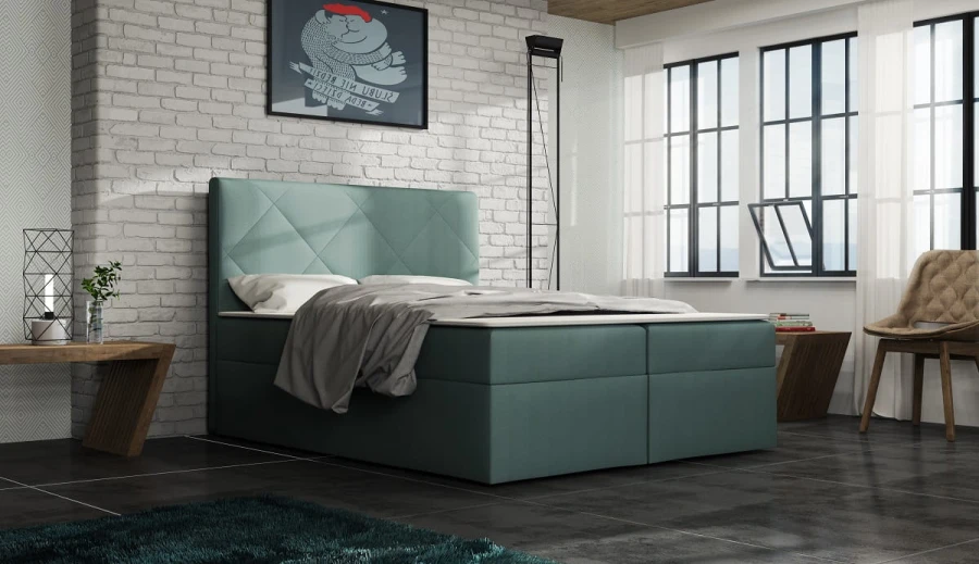 Modernes Boxspringbett in Türkis mit gestepptem Kopfteil vor weißer Backsteinwand.