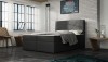 Modernes graues Boxspringbett mit gestepptem Kopfteil in Schlafzimmer-Ambiente.