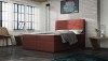 Bordeauxrotes Boxspringbett als Blickfang im hellen Schlafzimmer.