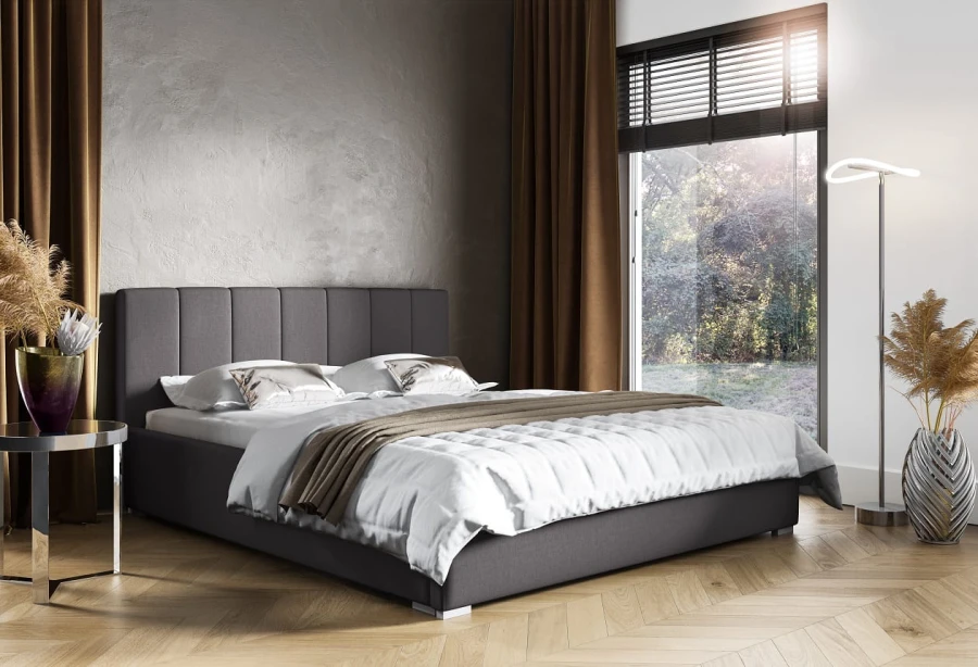Dunkelgraues Polsterbett mit gestepptem Kopfteil in einem modern eingerichteten Schlafzimmer.