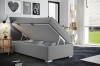 Boxspringbett Grau mit geöffnetem Bettkasten für Stauraum im Schlafzimmer.