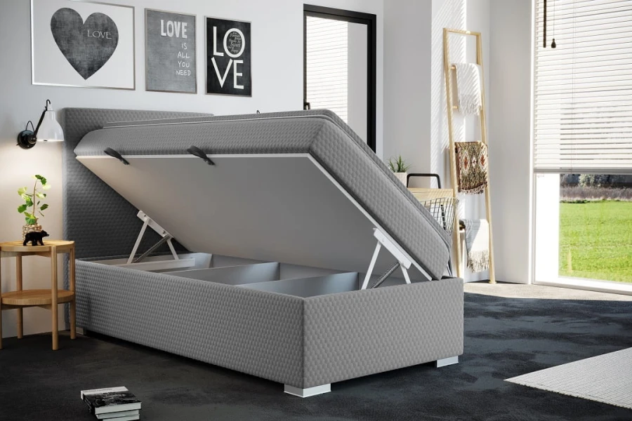 Boxspringbett Grau mit geöffnetem Bettkasten für Stauraum im Schlafzimmer.