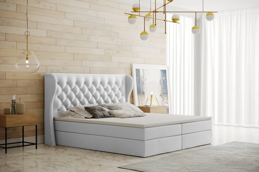 Weißes Boxspringbett mit gestepptem Kopfteil in modernem Schlafzimmer-Design.
