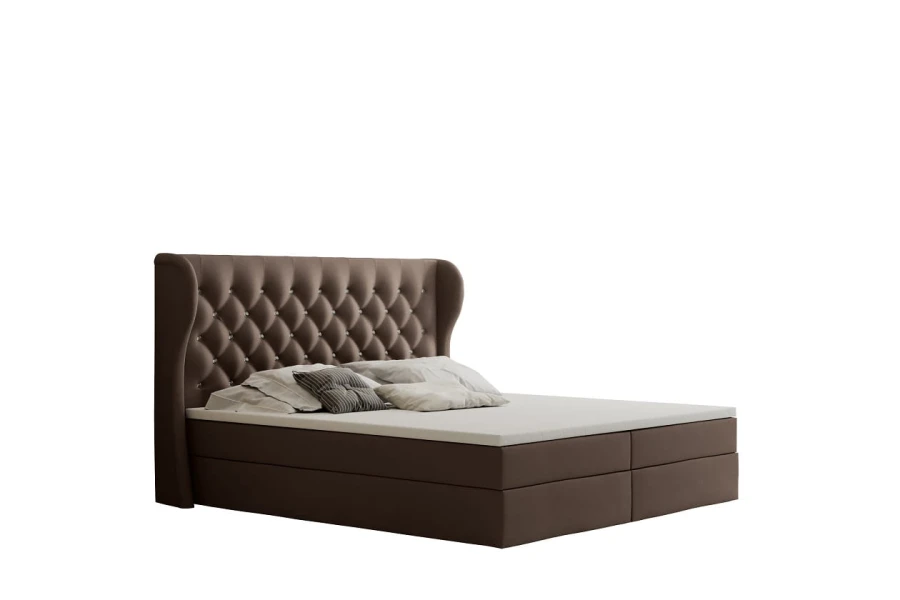 Braunes Boxspringbett mit gestepptem Kopfteil isoliert auf weißem Hintergrund.